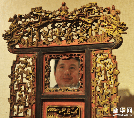（2）2月9日,，一位市民在觀看一個工藝繁復的帶鏡木雕盆架。