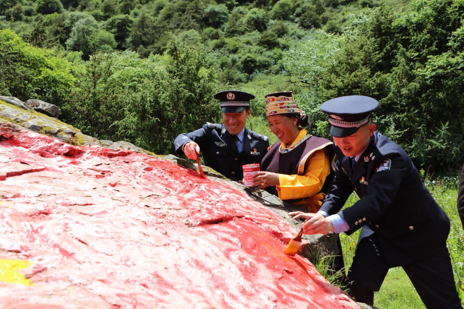 圖為玉麥邊境派出所民警與群眾描繪國(guó)旗.JPG